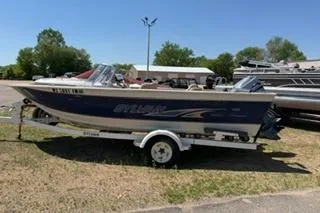 The Image of 1998 Sylvan 2000 Eliminator boat on trailer, parked outdoors on sunny day. - 1