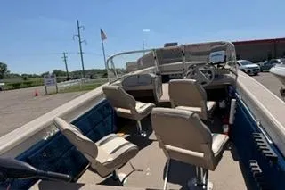 Slide: The Image of 1998 Sylvan 2000 Eliminator boat interior with beige seating and steering console. - 4
