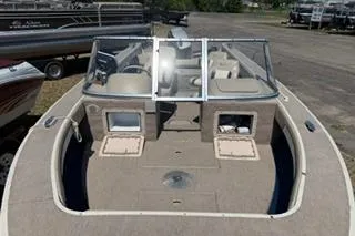 Slide: The Image of 1998 Sylvan 2000 Eliminator boat with open deck and windshield, parked on a lot. - 5