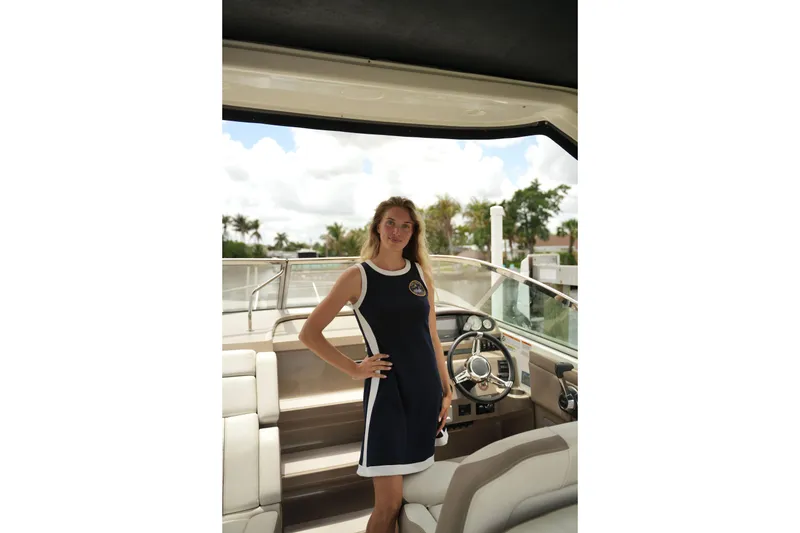 The Image of Woman standing on a 2018 Regal 28 Express boat, showcasing the helm area. - 1