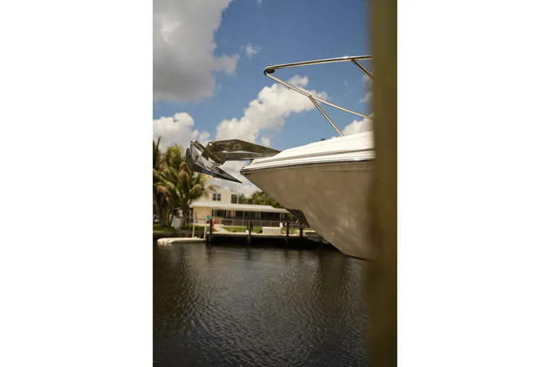 Slide: The Image of 2018 Regal 28 Express boat anchored by a waterfront home under a partly cloudy sky. - 10