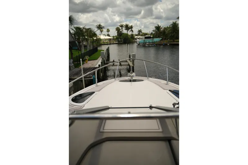 Slide: The Image of 2018 Regal 28 Express boat docked by a scenic canal with palm trees. - 12
