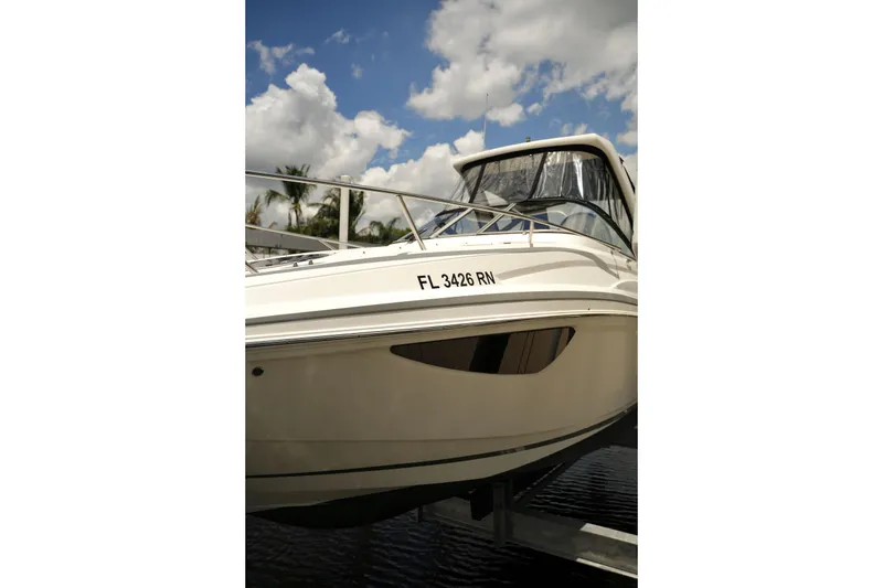 Slide: The Image of 2018 Regal 28 Express boat docked under a partly cloudy sky. - 23