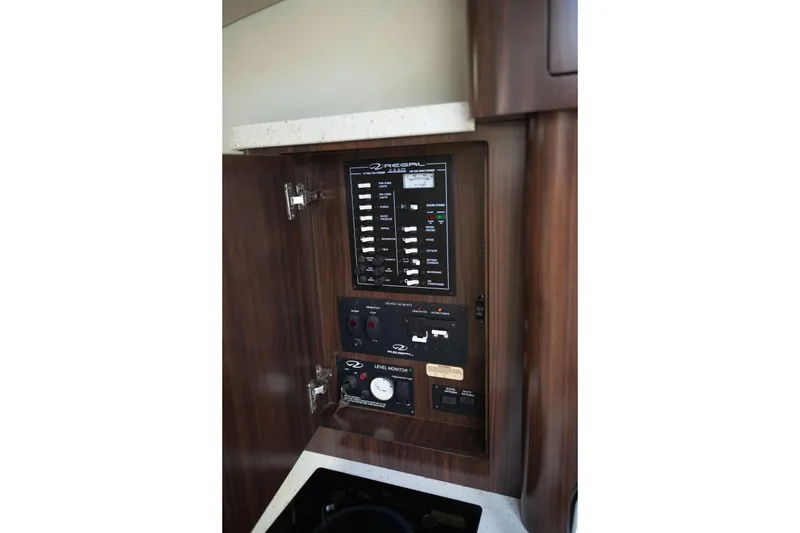 Slide: The Image of Control panel inside 2018 Regal 28 Express boat, featuring switches and gauges. - 27