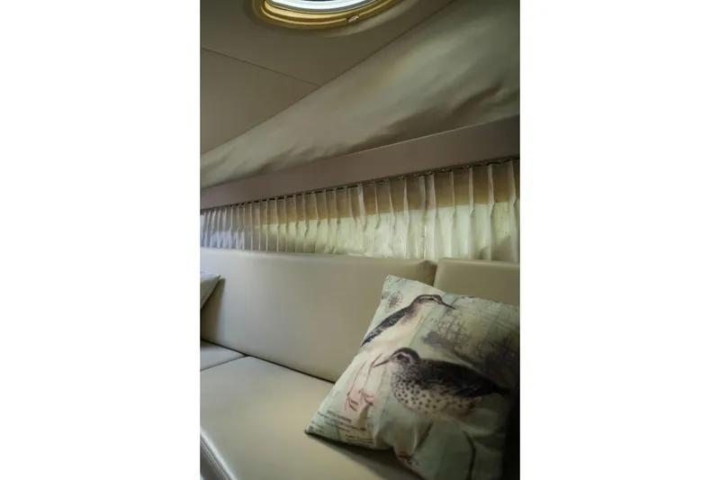 Slide: The Image of Interior of 2018 Regal 28 Express boat with beige seating and decorative bird pillow. - 30