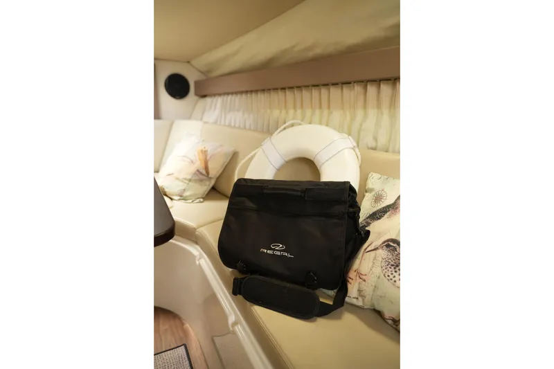 Slide: The Image of Interior of 2018 Regal 28 Express boat with life preserver and branded bag on seating. - 34