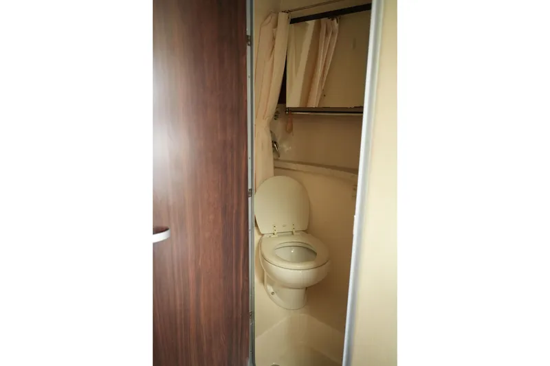 Slide: The Image of Bathroom interior of 2018 Regal 28 Express boat, featuring a toilet and shower curtain. - 36