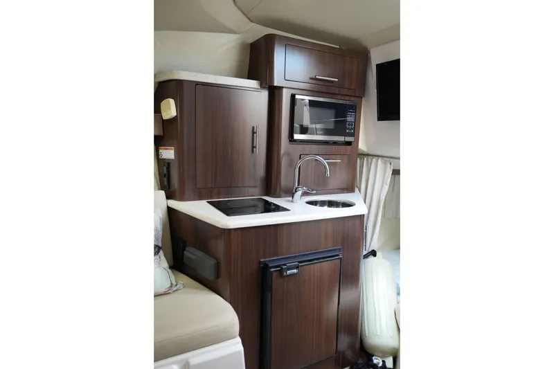 Slide: The Image of Compact kitchen area in a 2018 Regal 28 Express boat with microwave and sink. - 39