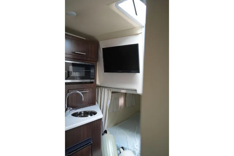 Slide: The Image of Interior of 2018 Regal 28 Express boat with kitchenette and TV setup. - 40