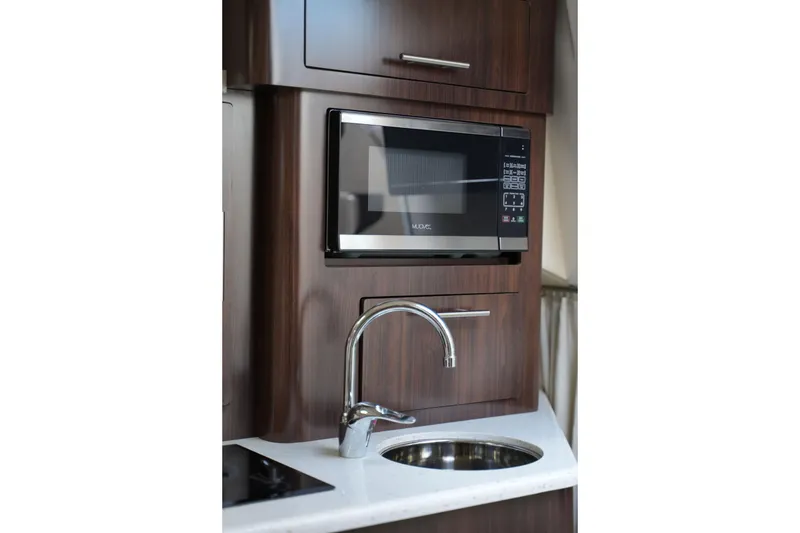 Slide: The Image of Microwave and sink in 2018 Regal 28 Express boat kitchen area. - 41
