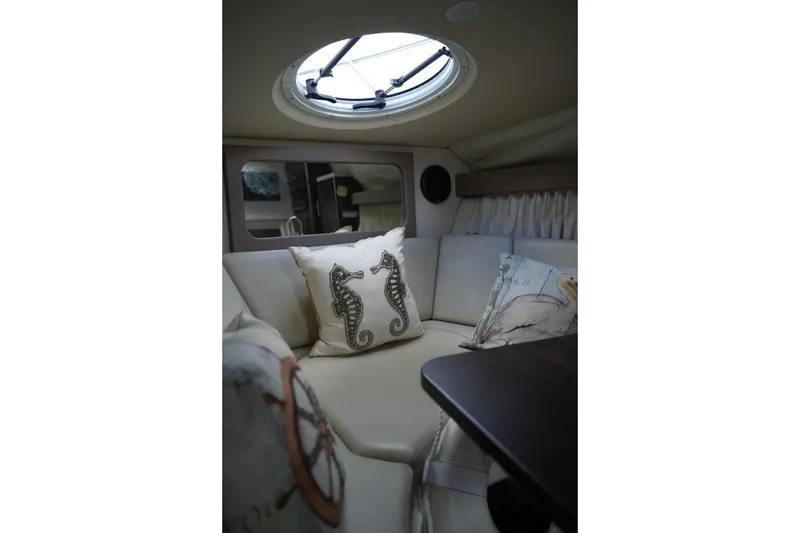 Slide: The Image of Interior of 2018 Regal 28 Express boat with seahorse-themed pillows and round skylight. - 43