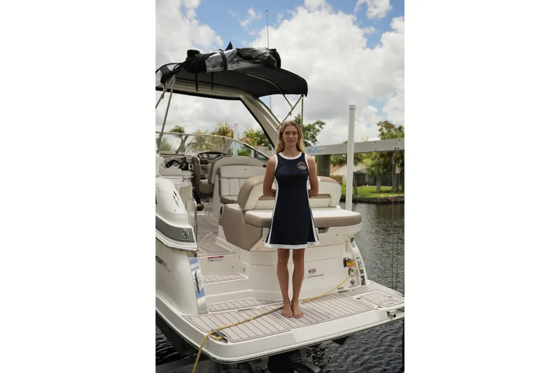 Slide: The Image of Woman standing on a 2018 Regal 28 Express boat docked by a canal. - 44