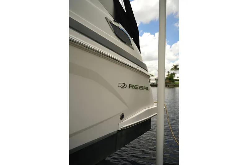 Slide: The Image of 2018 Regal 28 Express boat docked by the water, showcasing sleek design. - 5