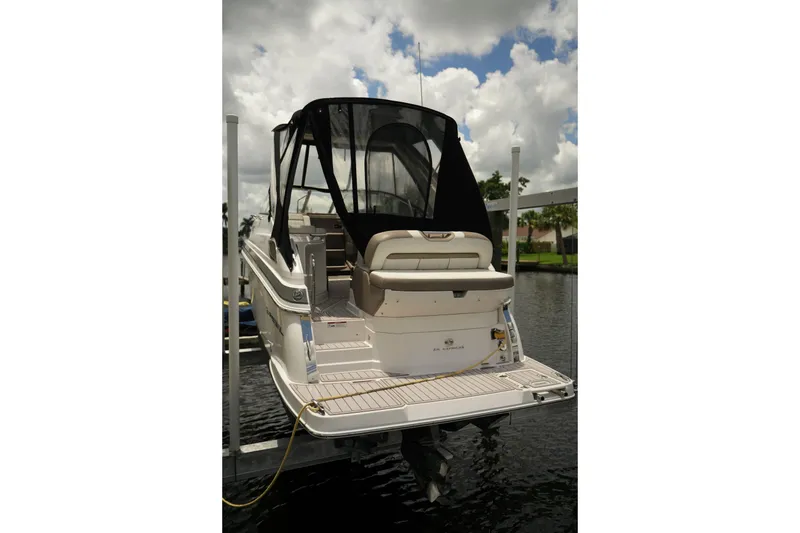 Slide: The Image of 2018 Regal 28 Express boat docked, featuring a black canopy and spacious deck. - 7