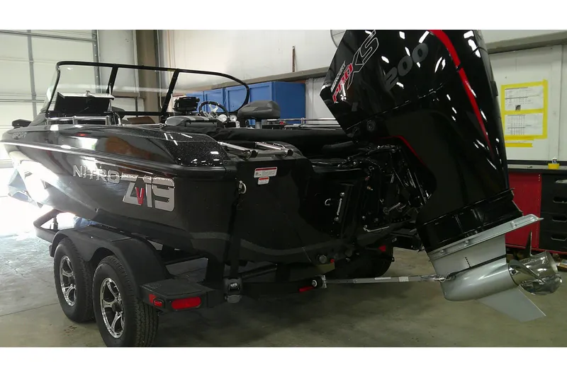 The Image of 2026 Nitro ZV19 Sport Pro boat with powerful outboard motor in a garage setting. - 0