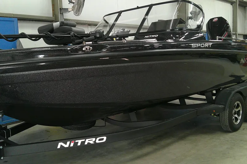 Slide: The Image of 2026 Nitro ZV19 Sport Pro boat in showroom, sleek black design on trailer. - 1