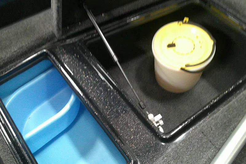 Slide: The Image of Storage compartments in a 2026 Nitro ZV19 Sport Pro boat, featuring a blue bin and yellow-lidded container. - 5