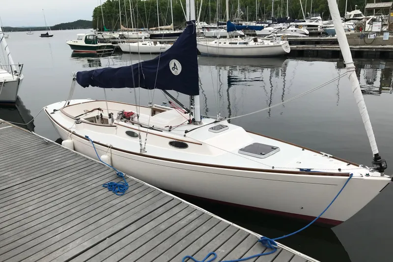 The Image of 2011 Alerion Sport 33 sailboat docked at a marina, surrounded by calm water. - 0