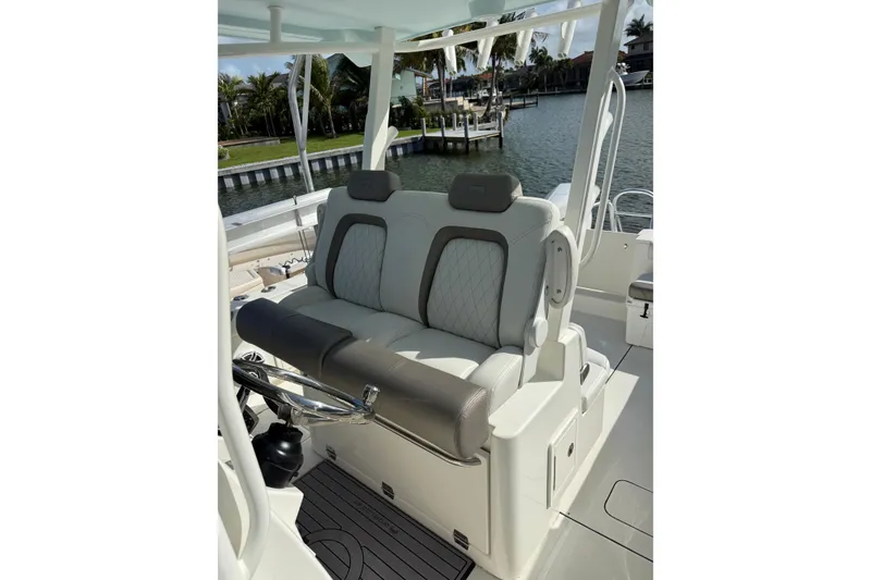 Slide: The Image of 2023 World Cat 325 CC boat interior with luxurious seating and steering wheel. - 11
