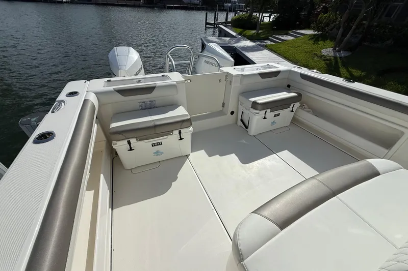 Slide: The Image of 2023 World Cat 325 CC boat deck with seating and coolers by the water. - 12
