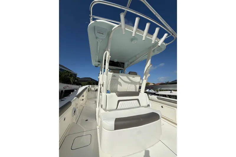 Slide: The Image of 2023 World Cat 325 CC boat interior with seating and rod holders under clear blue sky. - 16