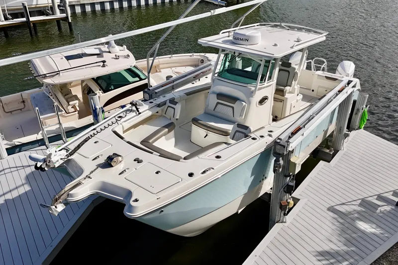 Slide: The Image of 2023 World Cat 325 CC boat docked at marina, featuring spacious deck and modern design. - 2