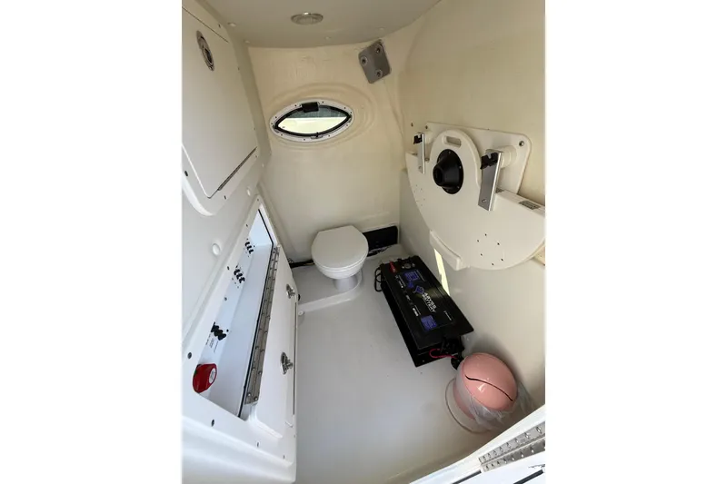 Slide: The Image of Interior of 2023 World Cat 325 CC boat, featuring a compact toilet and storage area. - 25