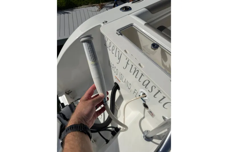 Slide: The Image of Hand holding a device on a 2023 World Cat 325 CC boat deck. - 28
