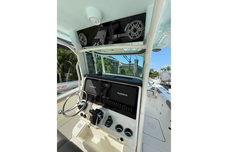 Slide: The Image of 2023 World Cat 325 CC boat dashboard with Garmin navigation system and steering wheel. - 30