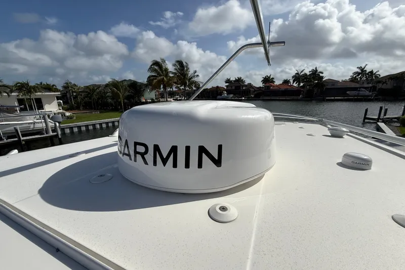 Slide: The Image of 2023 World Cat 325 CC boat with Garmin radar, docked near palm trees and waterfront homes. - 35