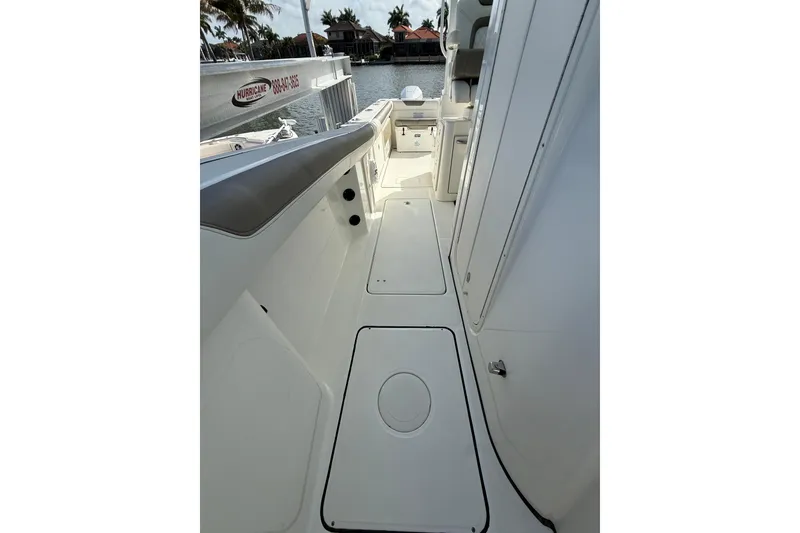 Slide: The Image of 2023 World Cat 325 CC boat interior, featuring sleek white deck and seating. - 36