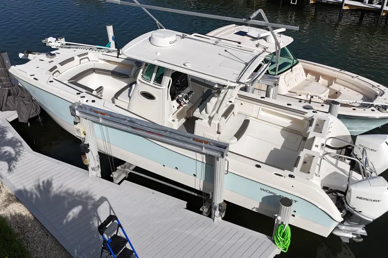 Slide: The Image of 2023 World Cat 325 CC boat docked, featuring spacious deck and twin Mercury engines. - 40
