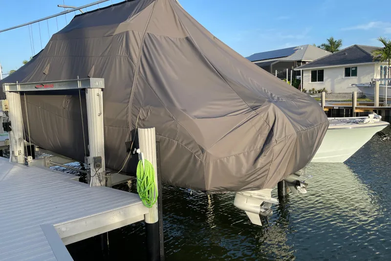 Slide: The Image of Covered 2023 World Cat 325 CC boat on a lift by the dock. - 48