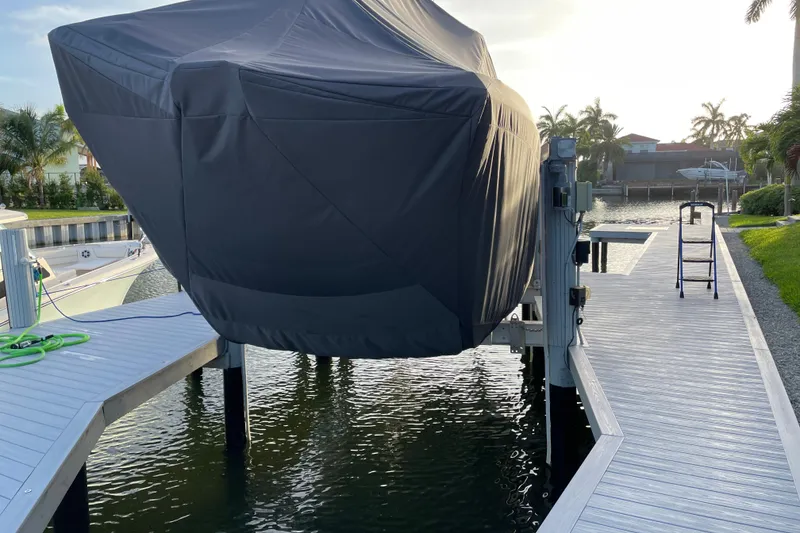 Slide: The Image of Covered 2023 World Cat 325 CC boat on a lift by a dockside. - 49