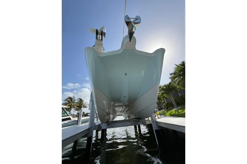 Slide: The Image of 2023 World Cat 325 CC boat on lift, viewed from below, with clear sky background. - 8
