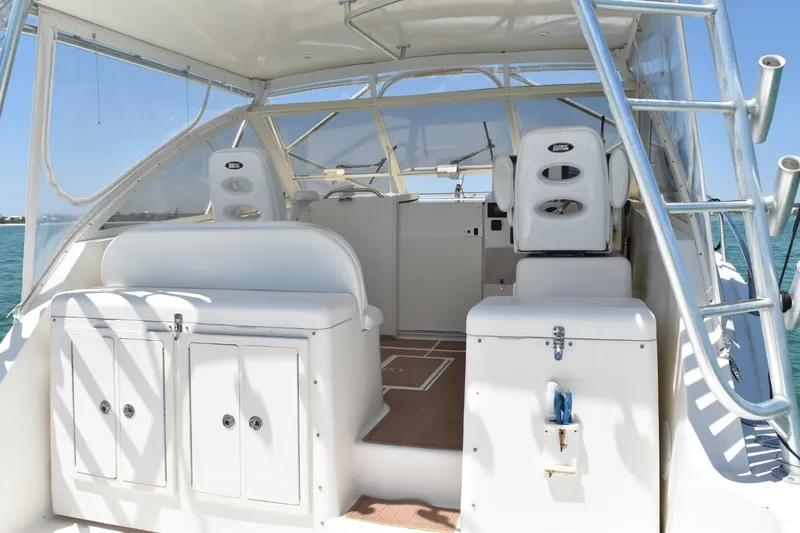Slide: The Image of 2006 Carolina Classic 32 boat interior with helm, seating, and storage, on a sunny day. - 15