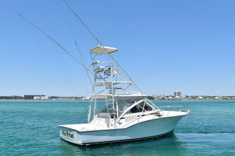 Slide: The Image of 2006 Carolina Classic 32 boat on clear blue water with city skyline in background. - 2
