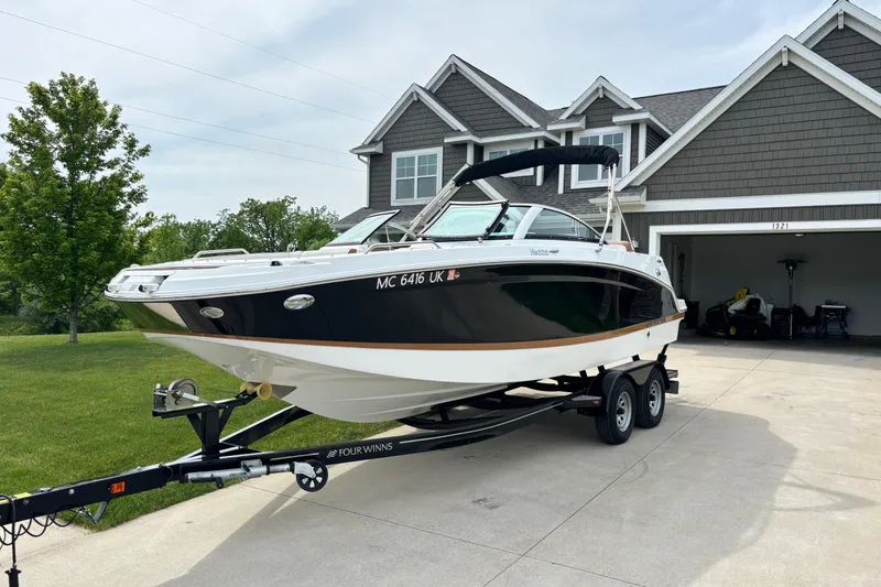 The Image of 2020 Four Winns HD220 boat on trailer in driveway, suburban home background. - 0