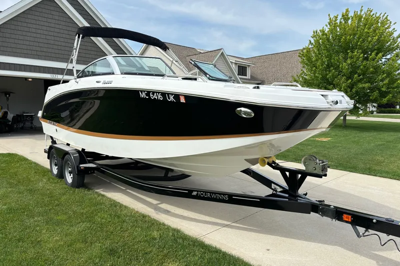 Slide: The Image of 2020 Four Winns HD220 boat on trailer in suburban driveway. - 1