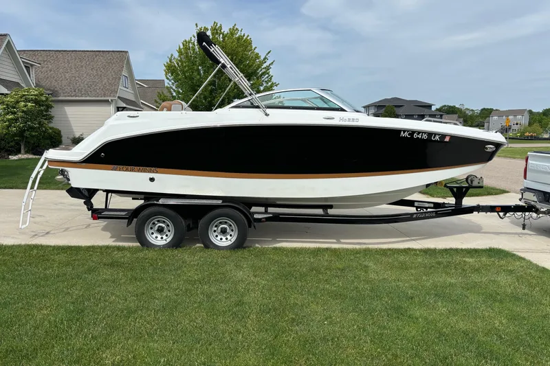 Slide: The Image of 2020 Four Winns HD220 boat on trailer in suburban driveway setting. - 3