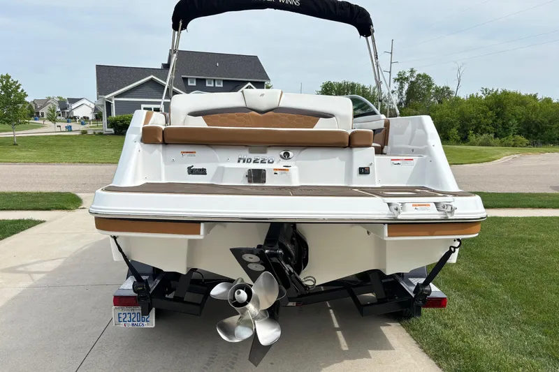 Slide: The Image of 2020 Four Winns HD220 boat on trailer, parked in suburban driveway. - 5