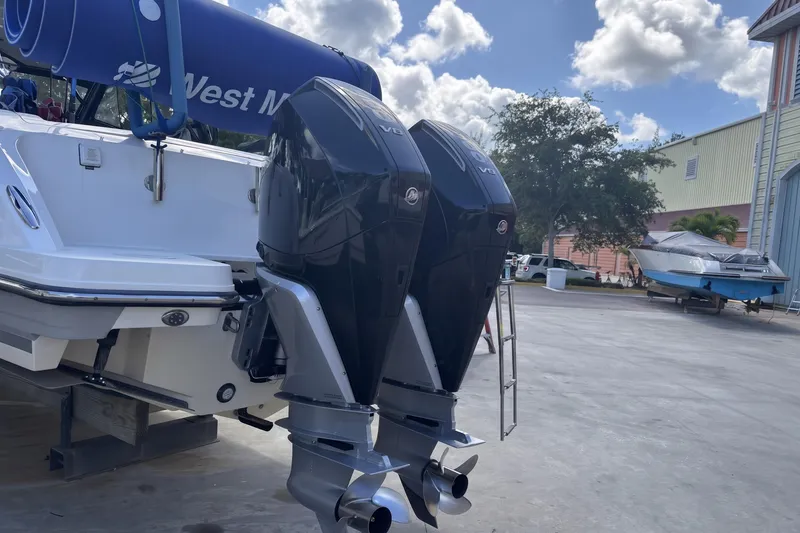 Slide: The Image of 2024 Boston Whaler 320 Vantage with dual outboard engines, docked outdoors. - 3