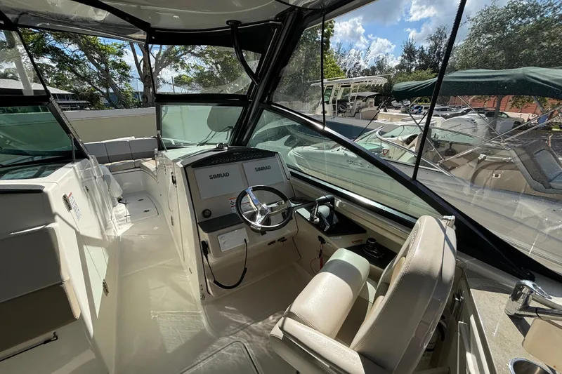 Slide: The Image of 2024 Boston Whaler 320 Vantage boat interior with steering wheel and seating. - 7