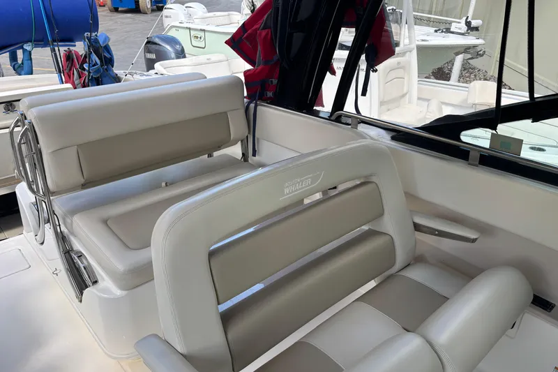 Slide: The Image of 2024 Boston Whaler 320 Vantage boat interior with beige seating and branded logo. - 8