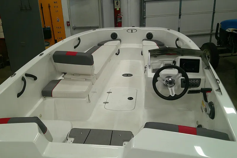 Slide: The Image of 2024 Tahoe T18 boat interior with steering wheel and seating in a garage setting. - 2