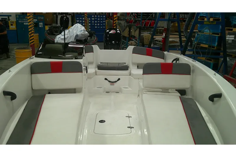 Slide: The Image of 2024 Tahoe T18 boat interior with gray and red seating in a workshop setting. - 3
