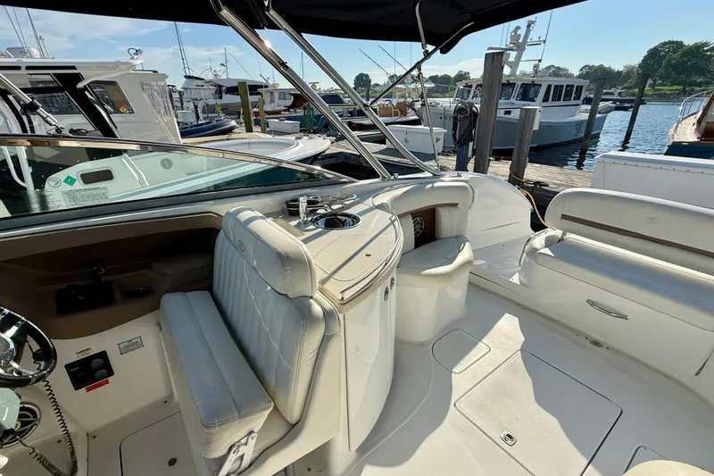Slide: The Image of 2007 Cobalt 323 boat interior with white seating at a marina. - 11