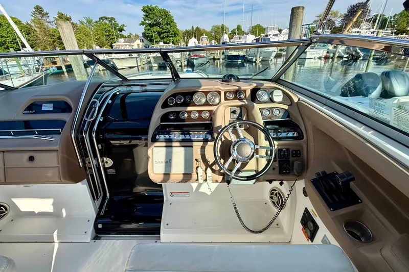 Slide: The Image of 2007 Cobalt 323 boat dashboard with steering wheel and navigation controls at marina. - 12