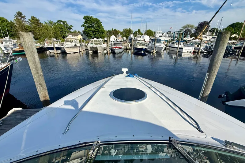 Slide: The Image of 2007 Cobalt 323 boat docked in a marina with surrounding boats and clear sky. - 9