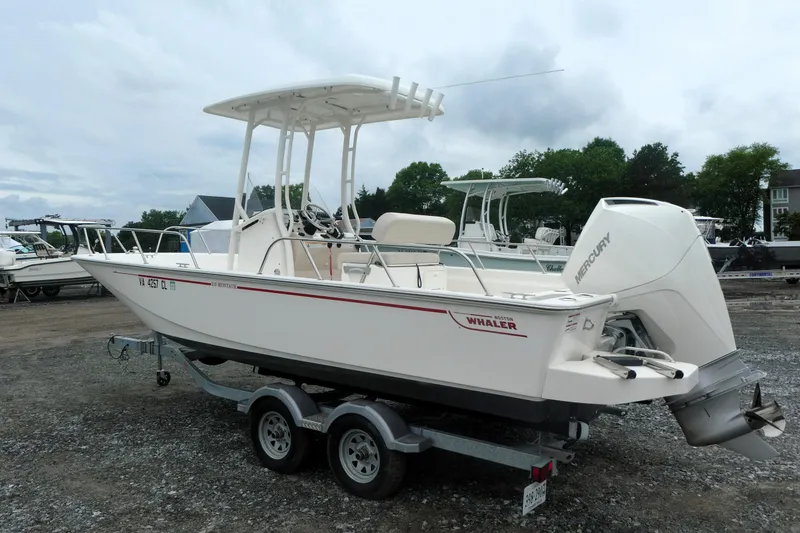 Slide: The Image of 2023 Boston Whaler 210 Montauk boat on trailer, featuring Mercury outboard engine. - 1